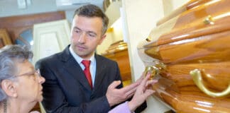 Elderly lady with funeral director choosing coffin