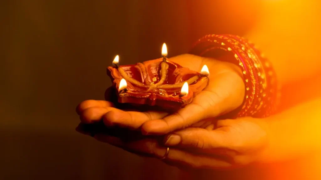 A picture of hands holding diyas, depicting the unity and togetherness of people during Diwali.